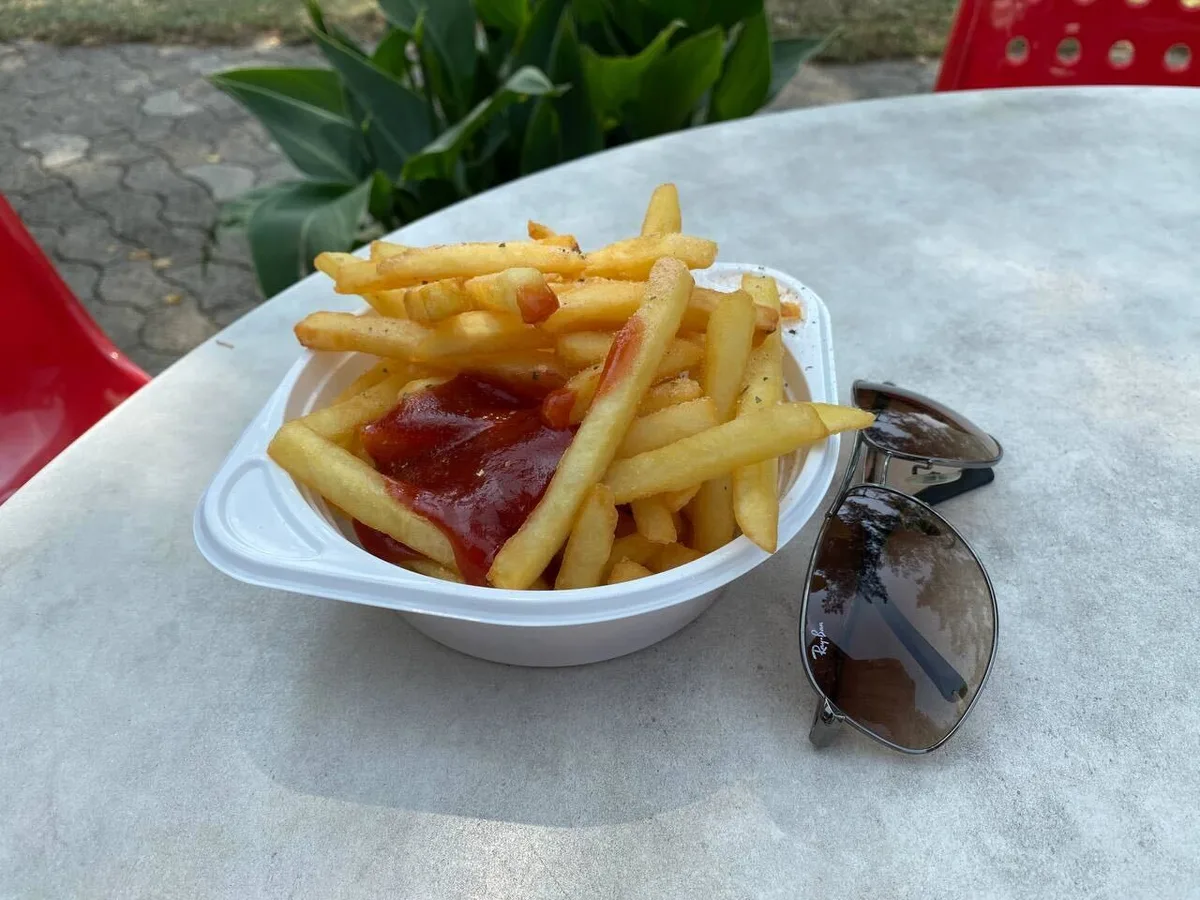 Portion Pommes, daneben eine Sonnenbrille.